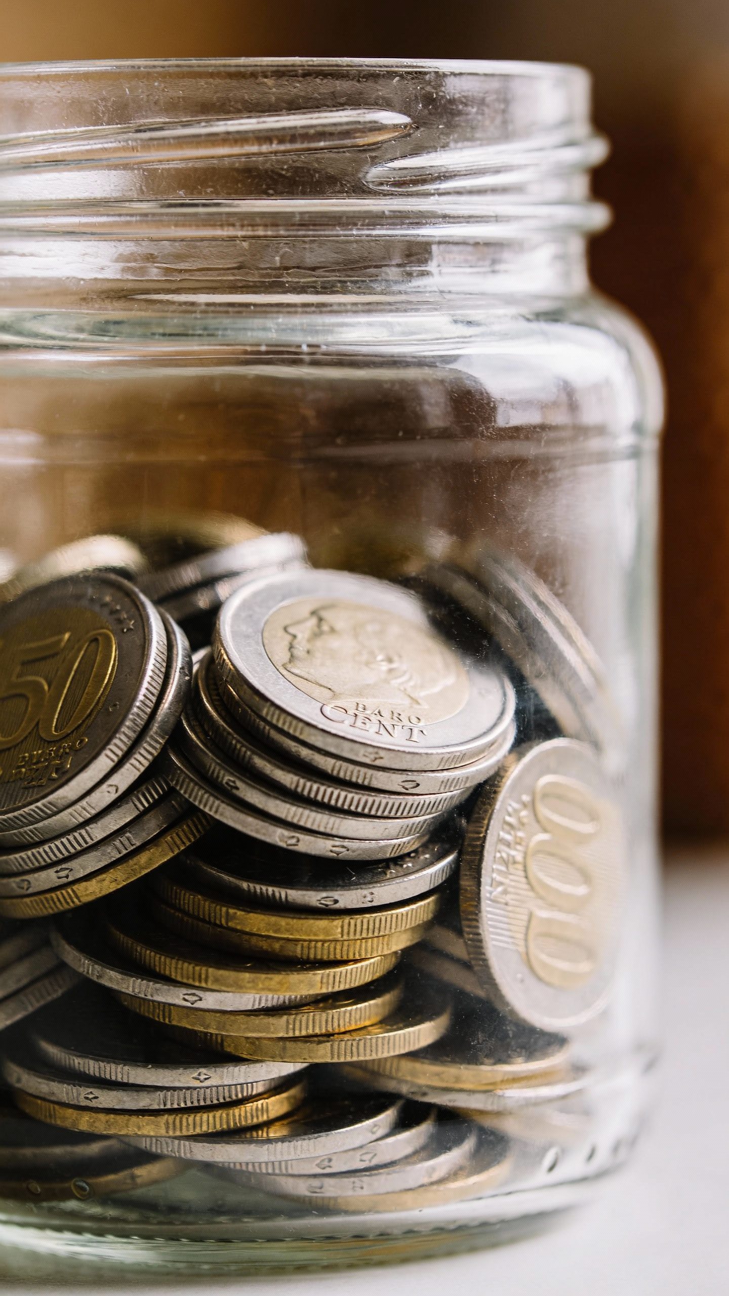 clear glass jar labeled “Emergency Fund” filled with coins