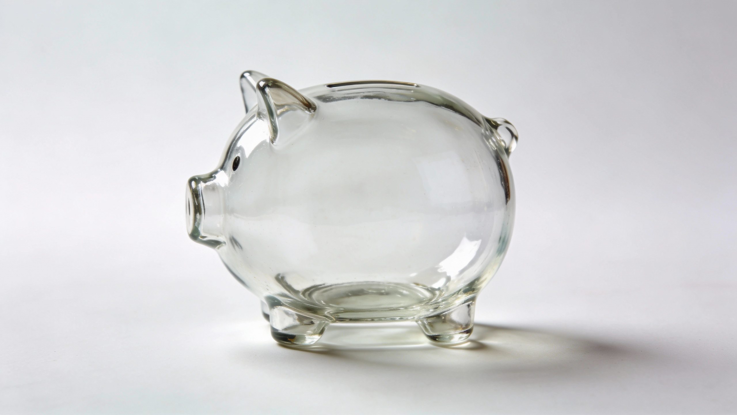 **Empty glass piggy bank against a plain background**  Each prompt focuses on a single, visually striking element from the article while maintaining professional simplicity.