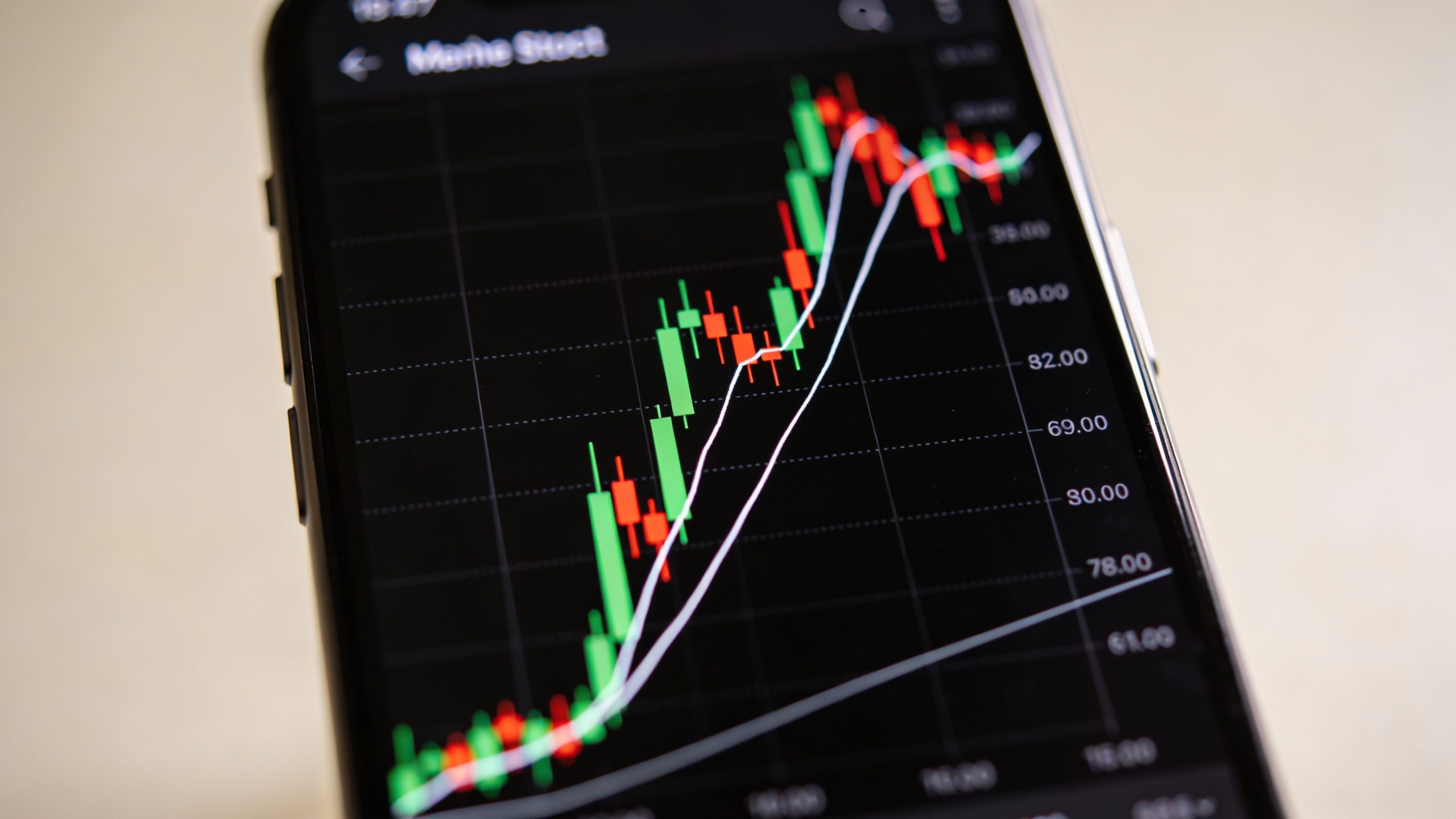 closeup of a smartphone showing a soaring meme stock chart