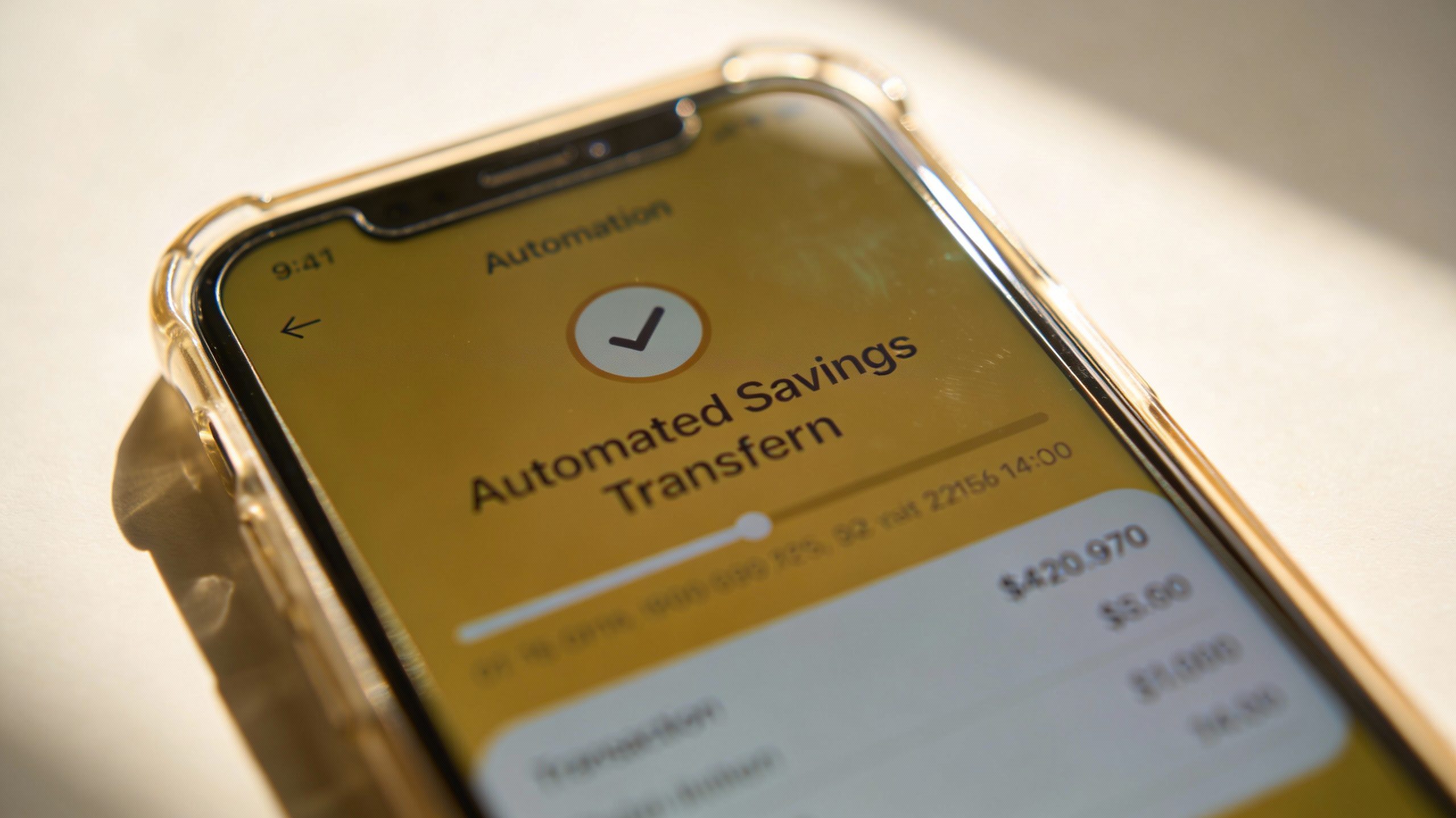 closeup of smartphone screen showing automated savings transfer confirmation