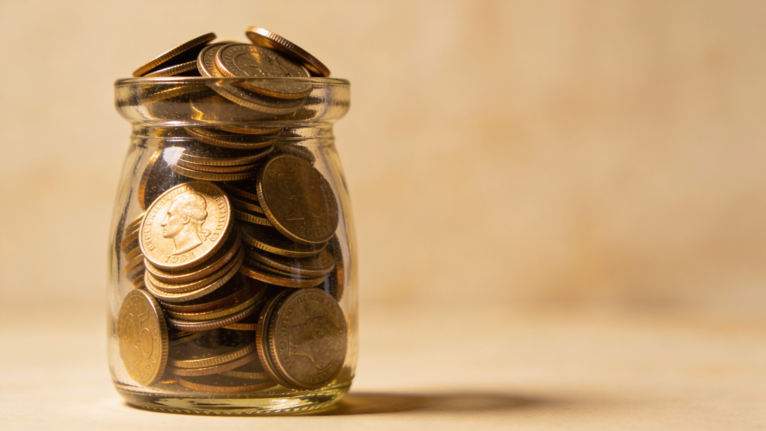 **Single glass jar filled with spare coins**