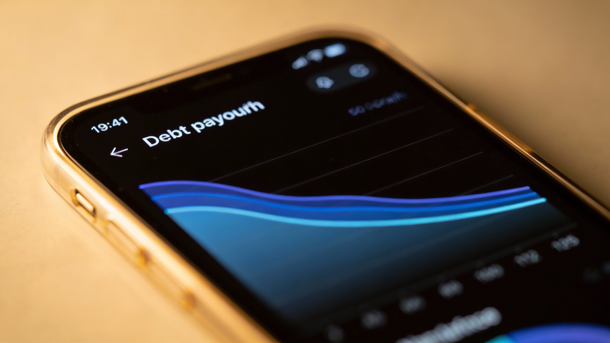 **Closeup of a smartphone screen showing a debt payoff app graph**