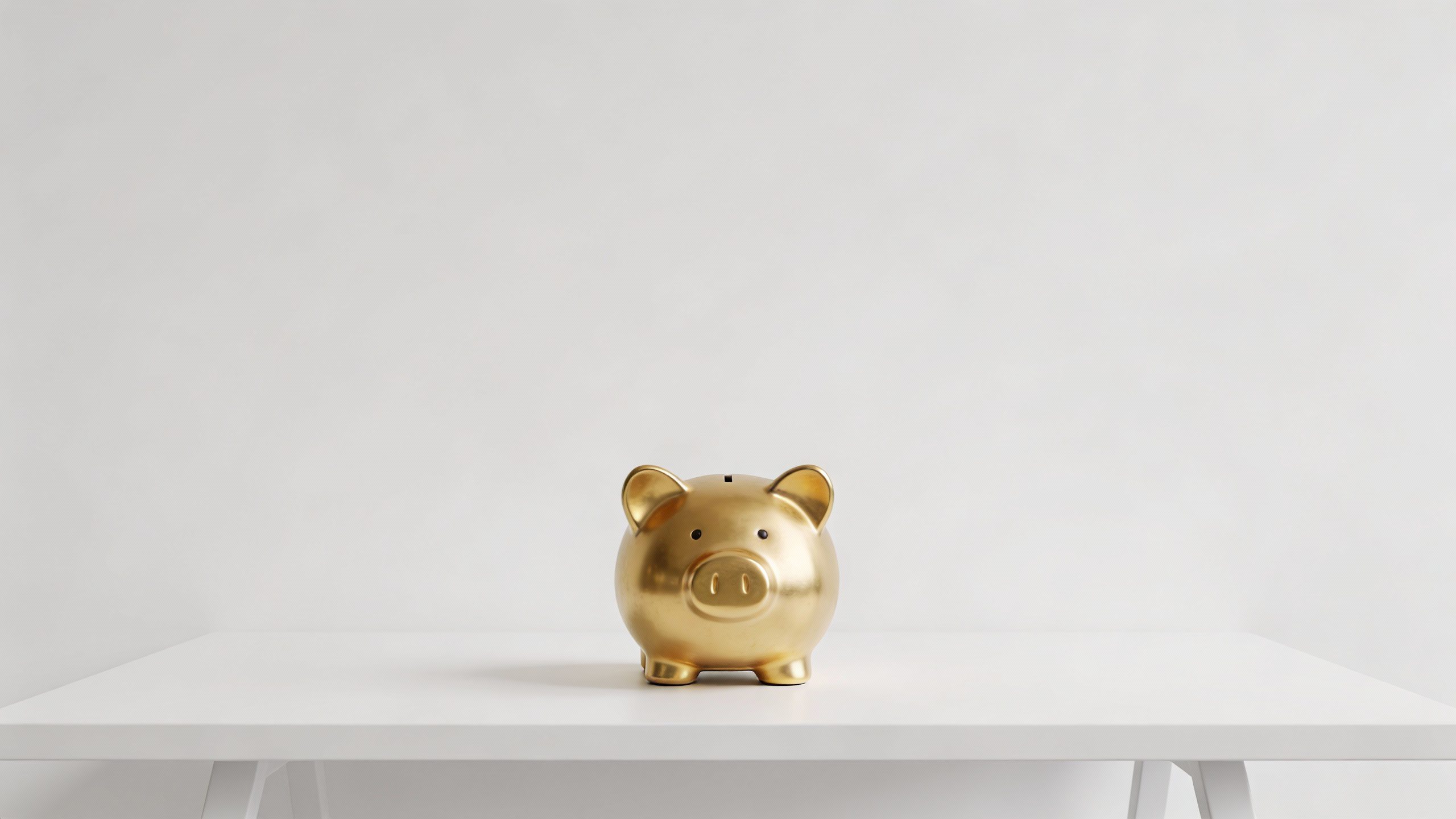 **Single golden piggy bank on a minimalist desk**