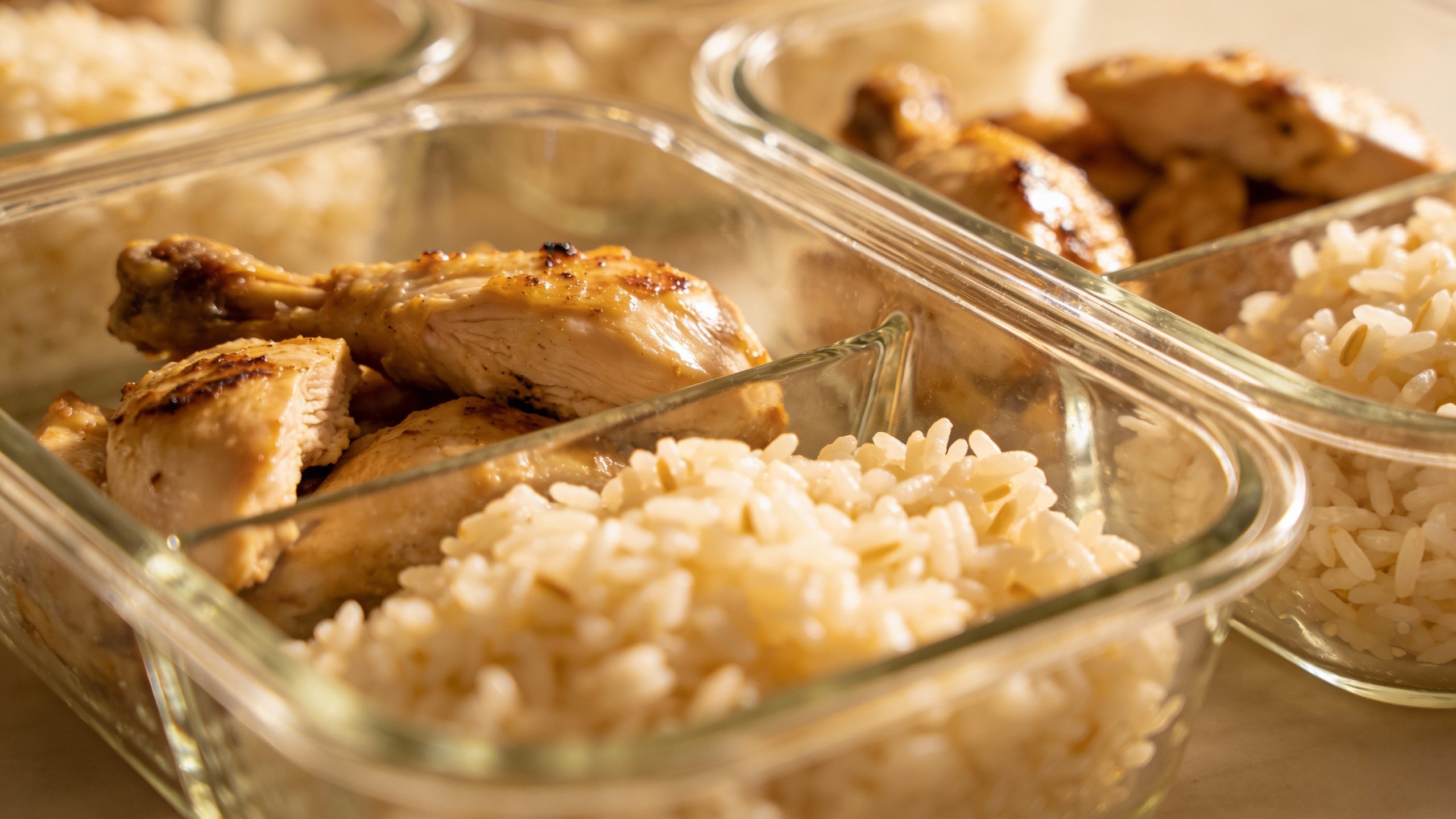 **Closeup of glass meal prep containers with chicken and rice**