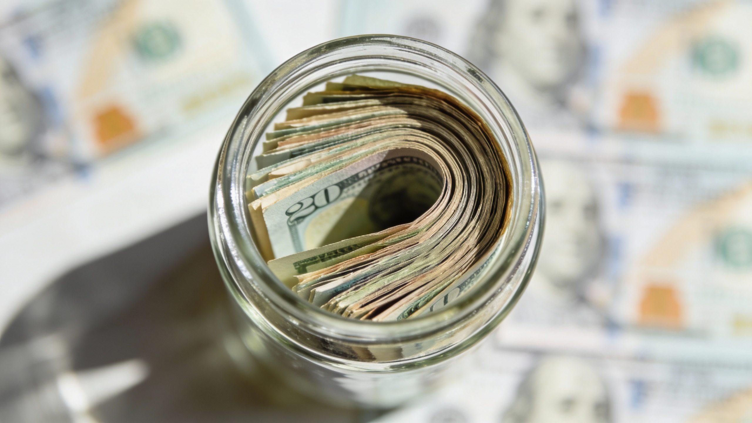 **Neat stack of emergency cash in a clear glass jar**
