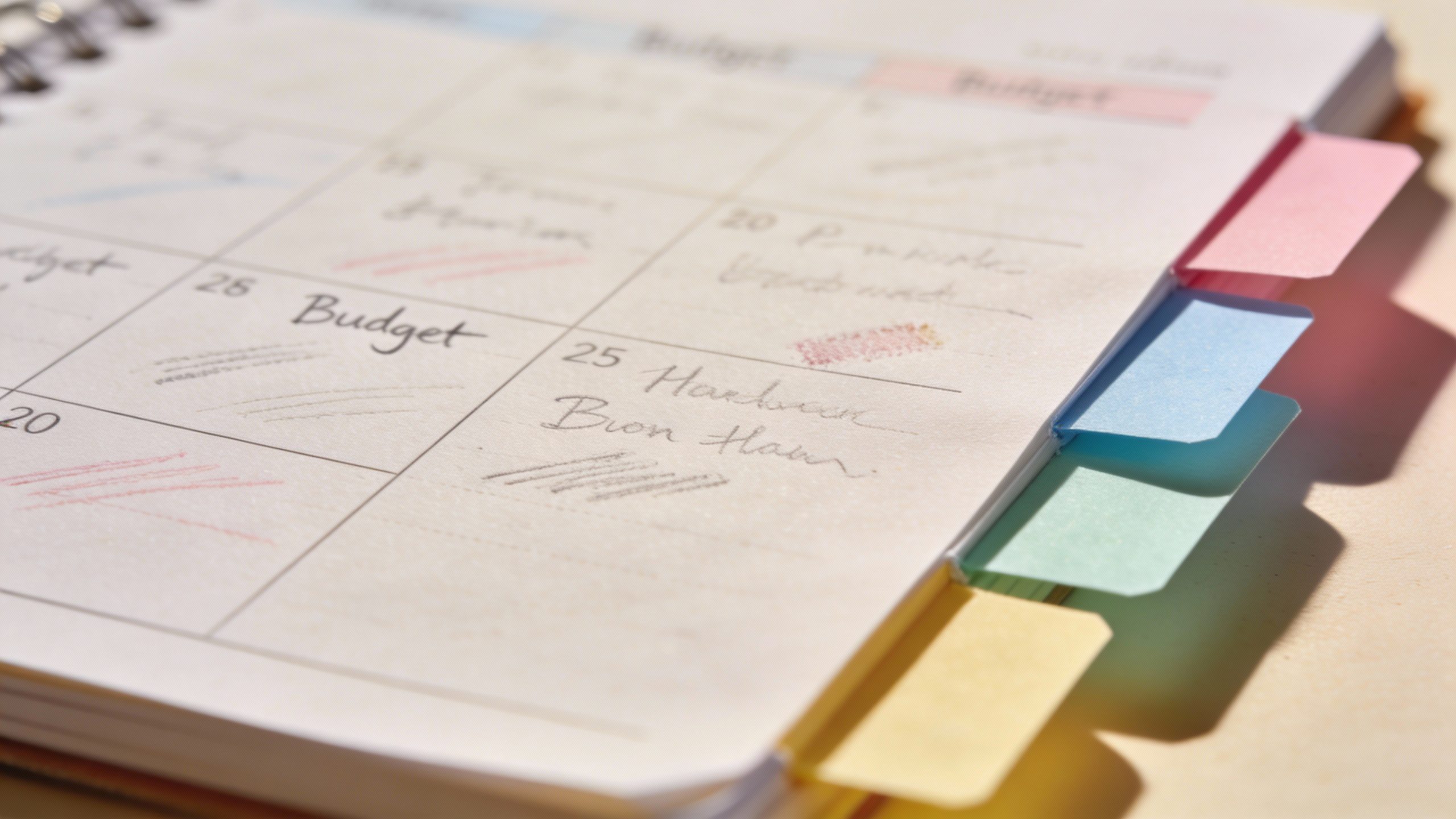 closeup of handwritten budget planner page with color-coded tabs