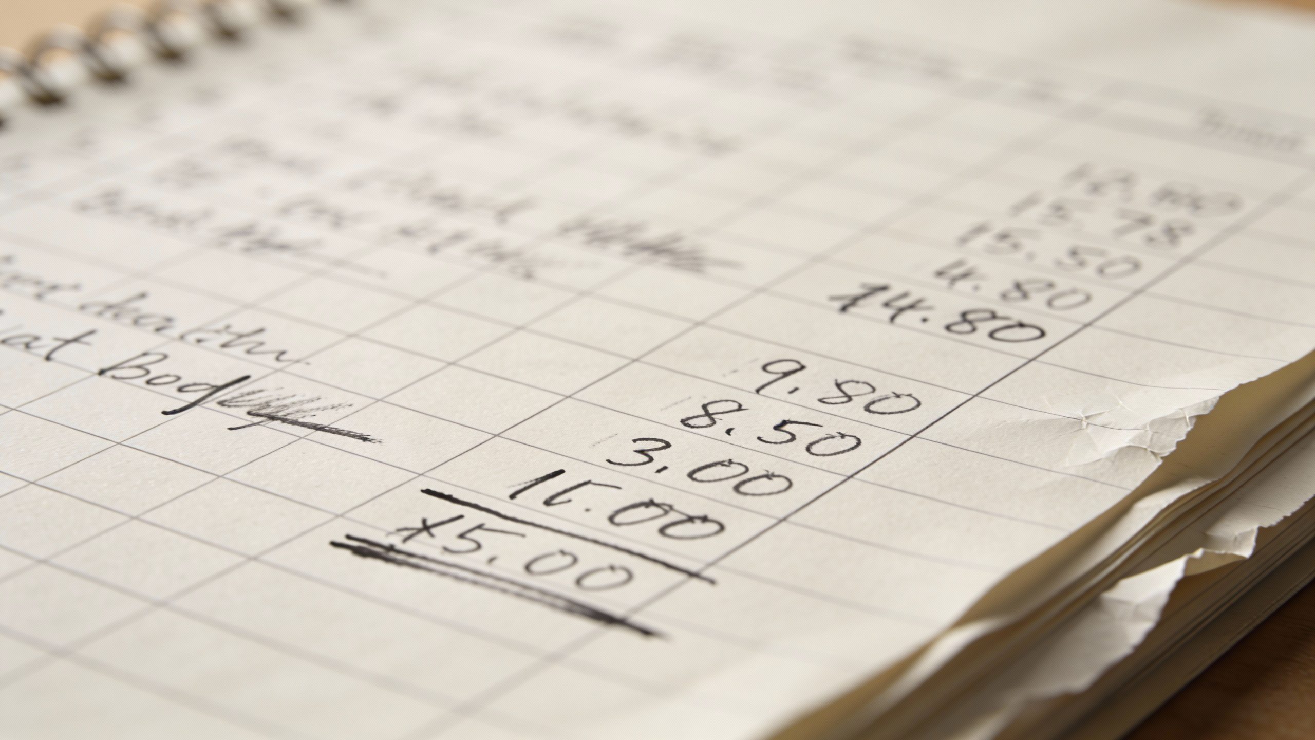 **Closeup of a handwritten budget on notebook paper**