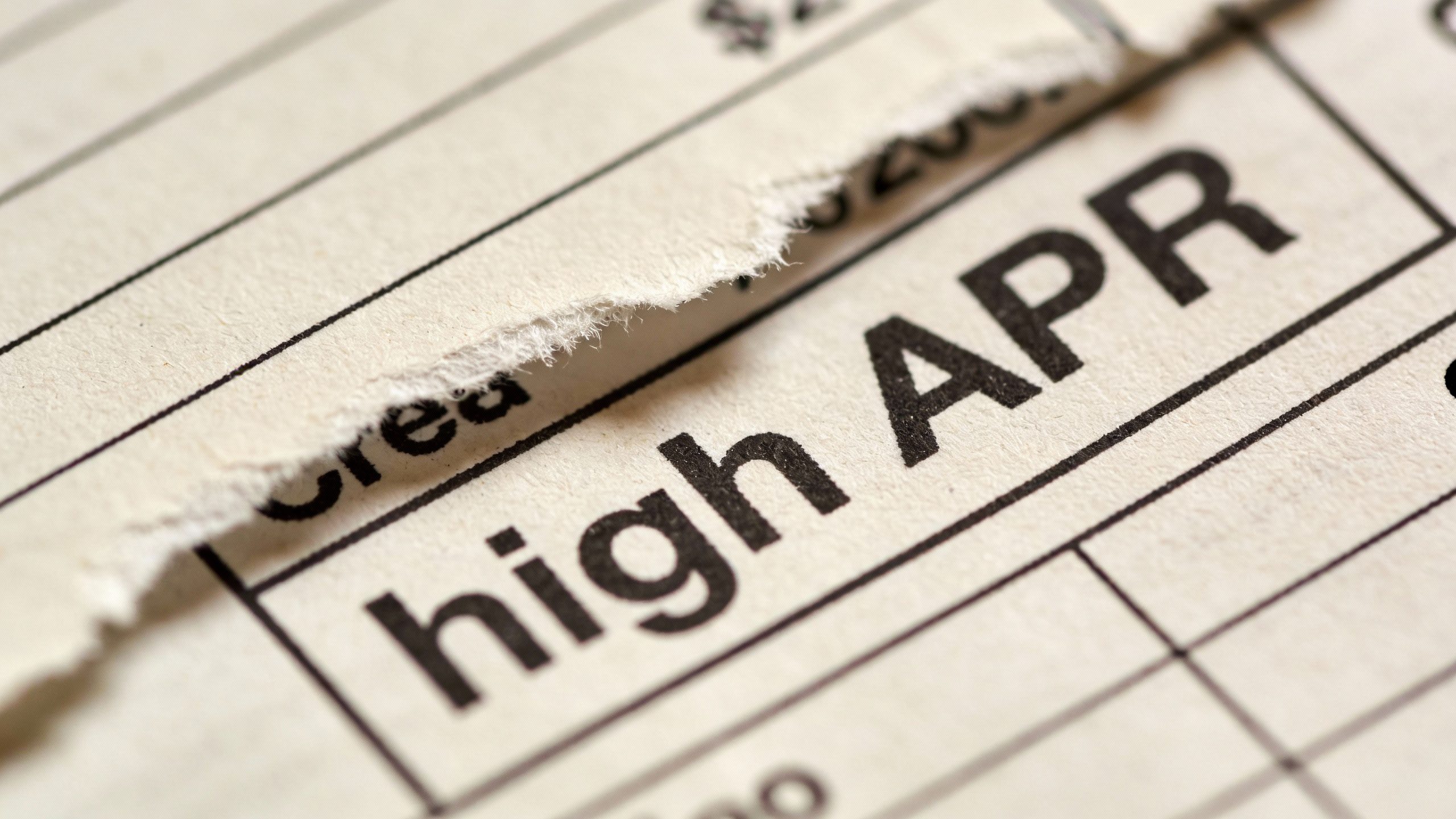 **Closeup of a torn credit card statement with high APR highlighted**