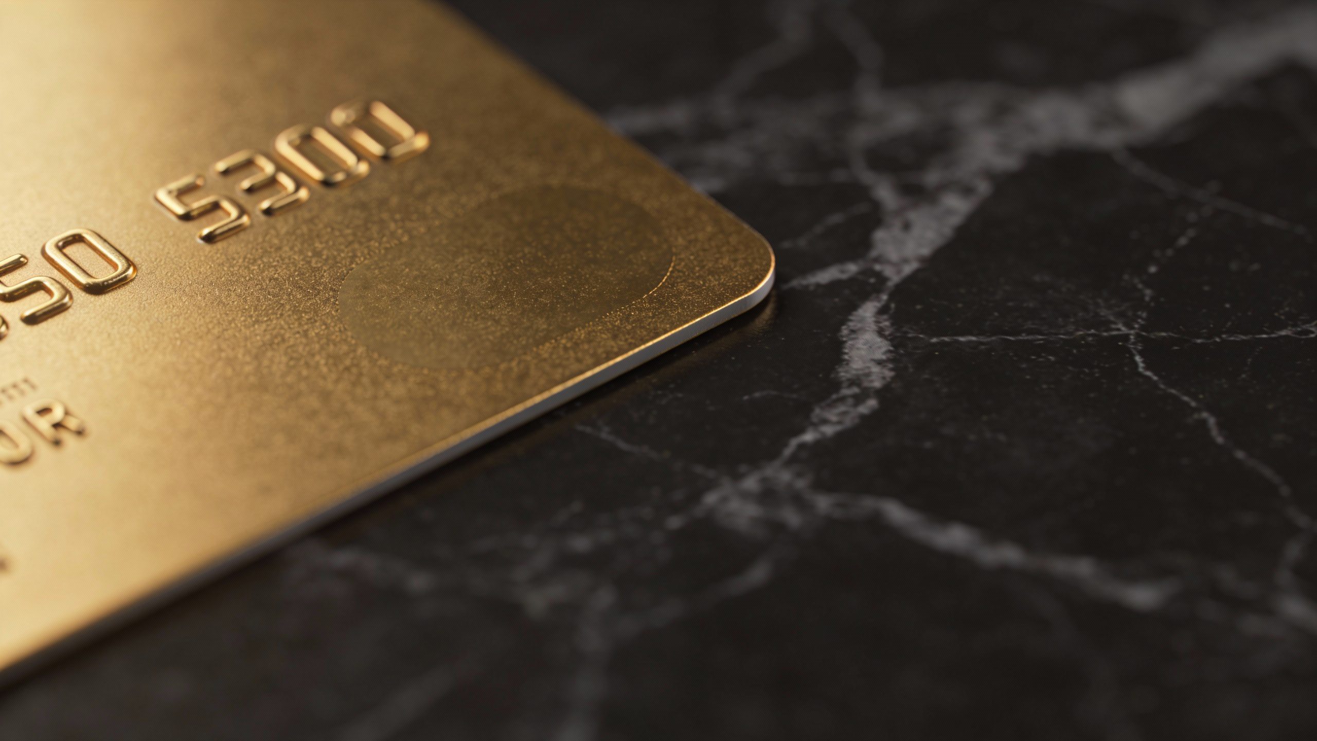 **Gold credit card on dark marble surface (closeup)**
