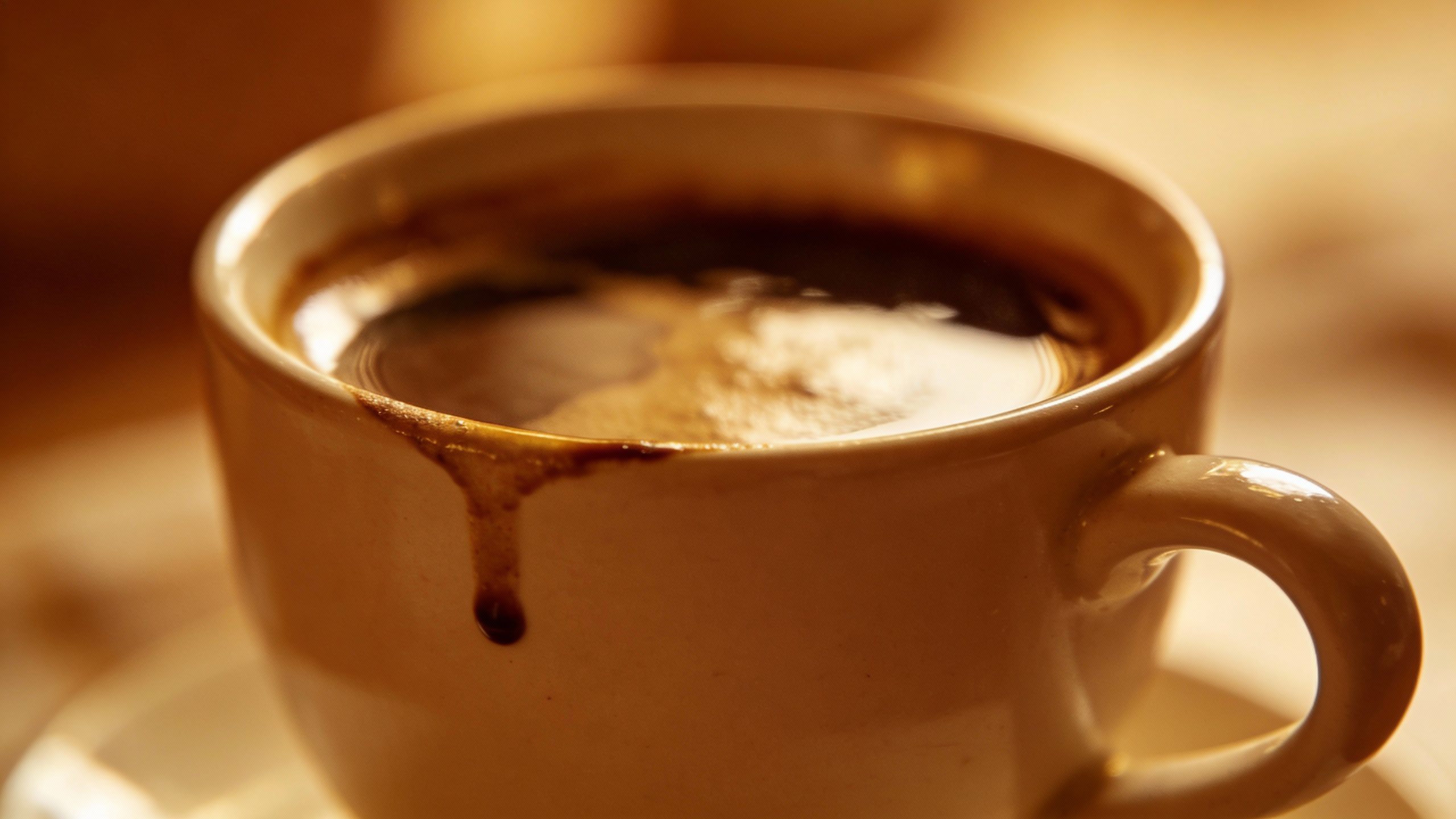 Closeup of a single coffee cup with subtle spill near edge