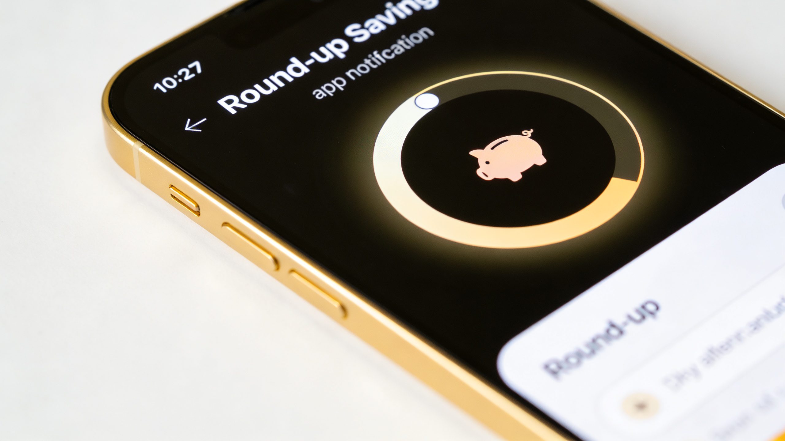 **Closeup of a smartphone screen showing a round-up savings app notification**