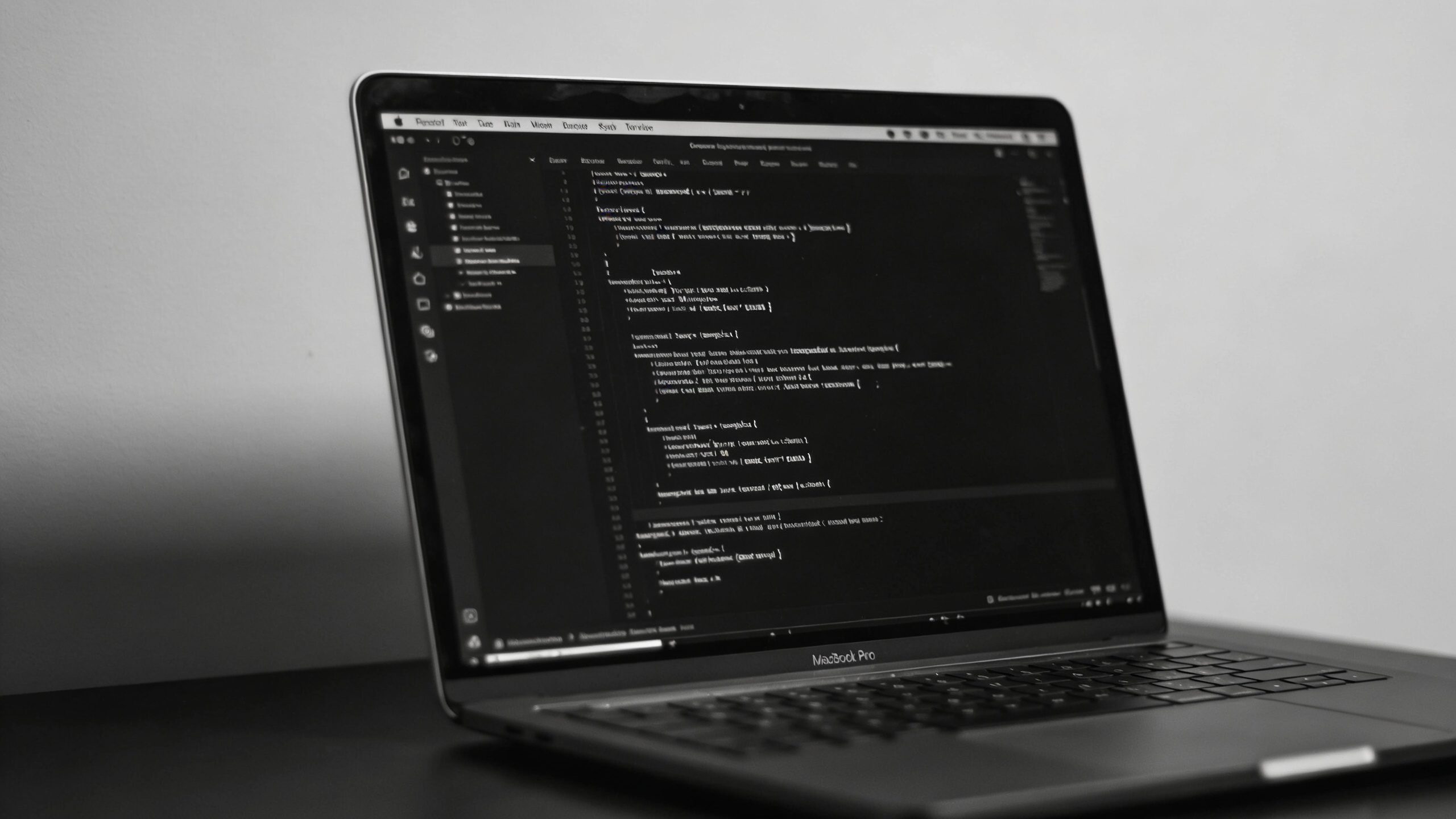 single open laptop with code editor in dark mode