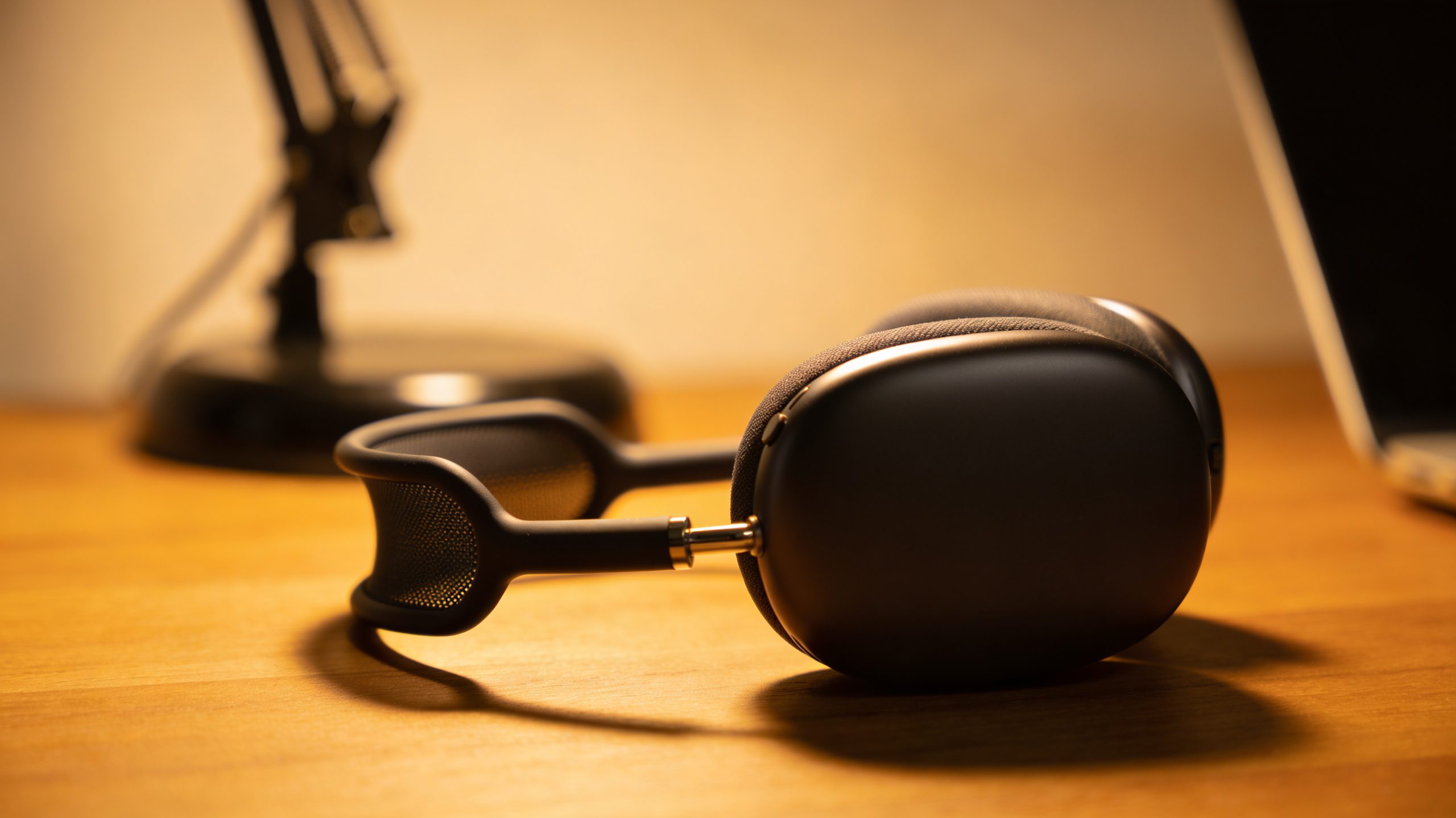 single noise-cancelling headset glowing under desk lamp