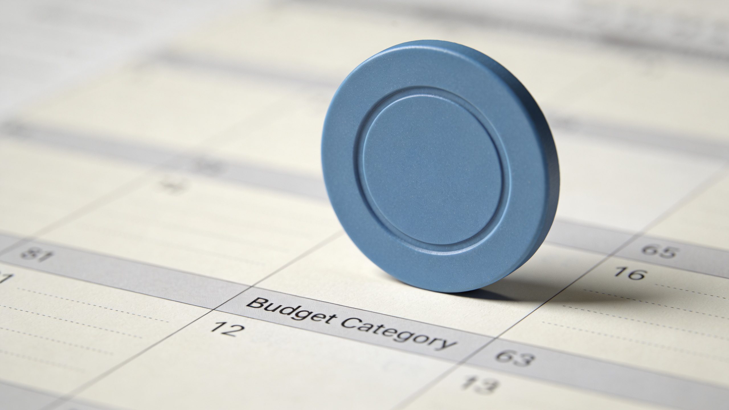 Closeup of a single color-coded budget category chip on a desk planner