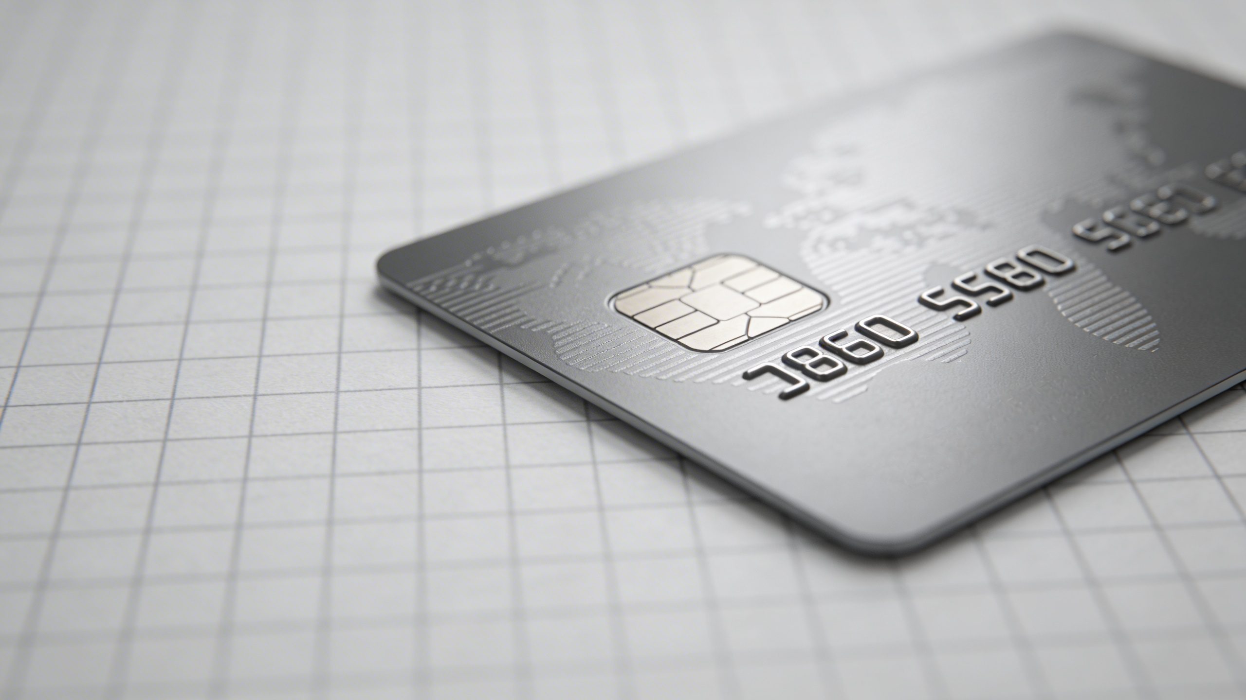 Closeup of a single credit card on a graph paper background