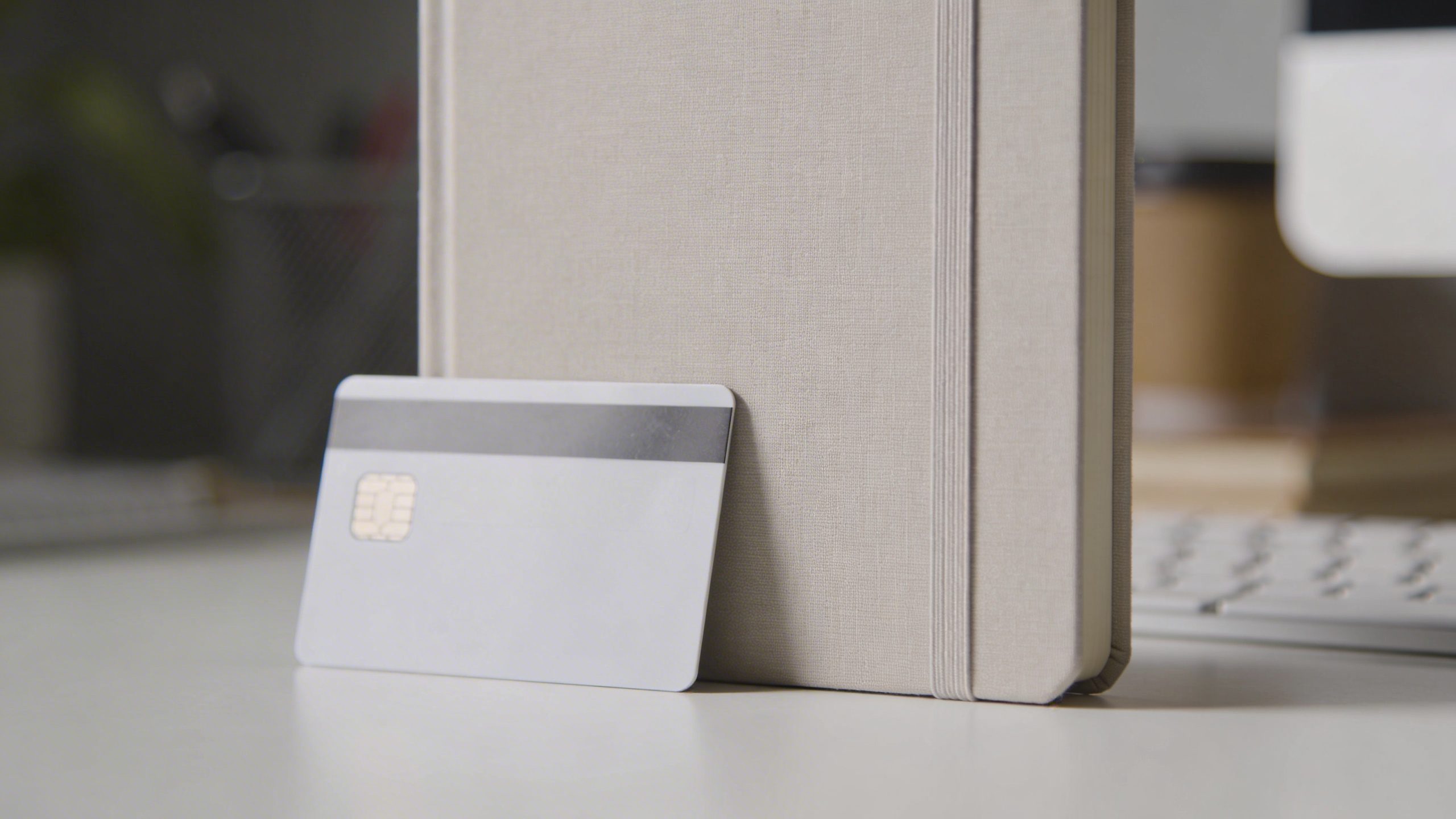 closeup of a single credit card and notebook on a clean desk