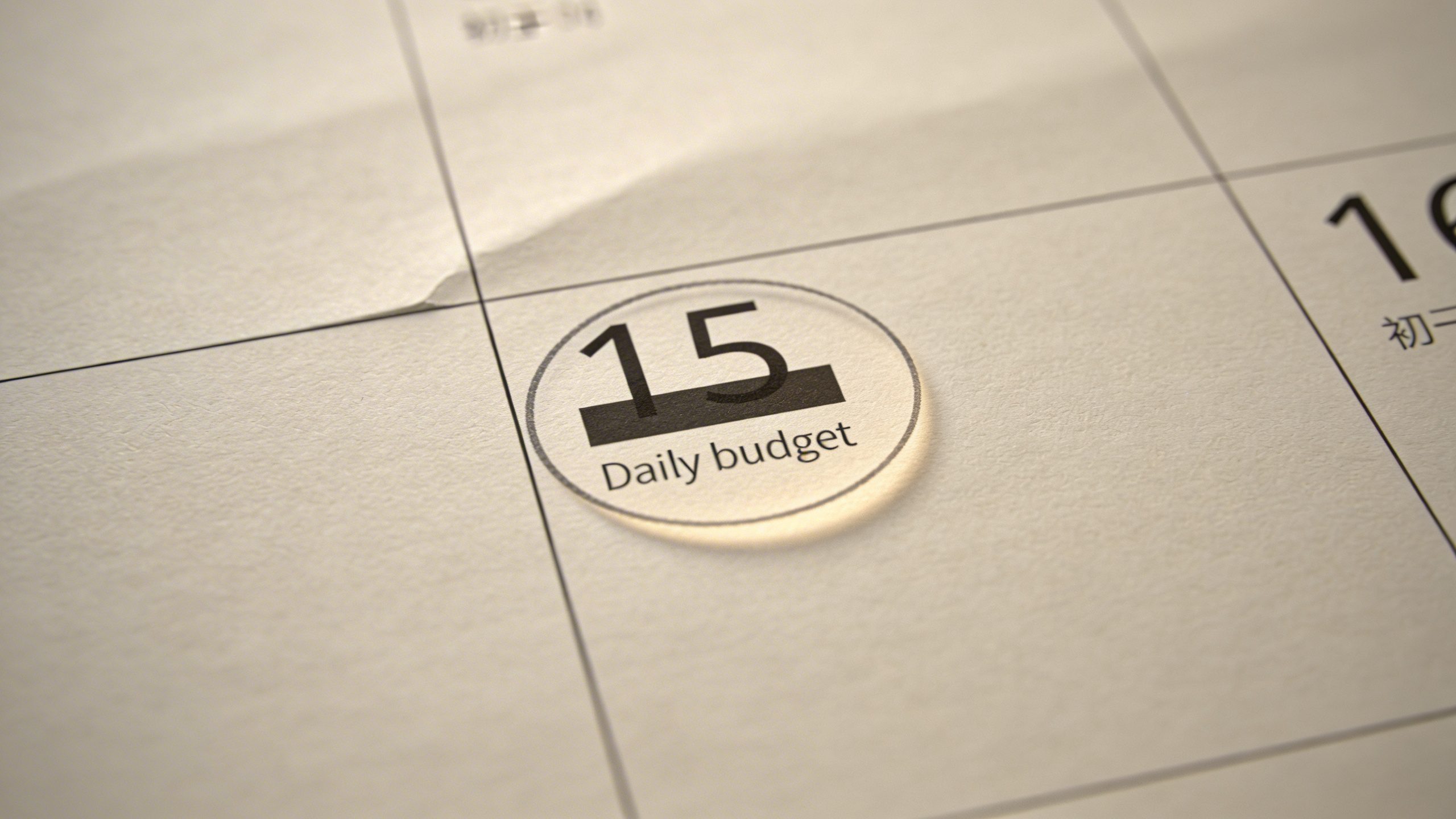 Closeup of a single calendar page with a highlighted daily budget check