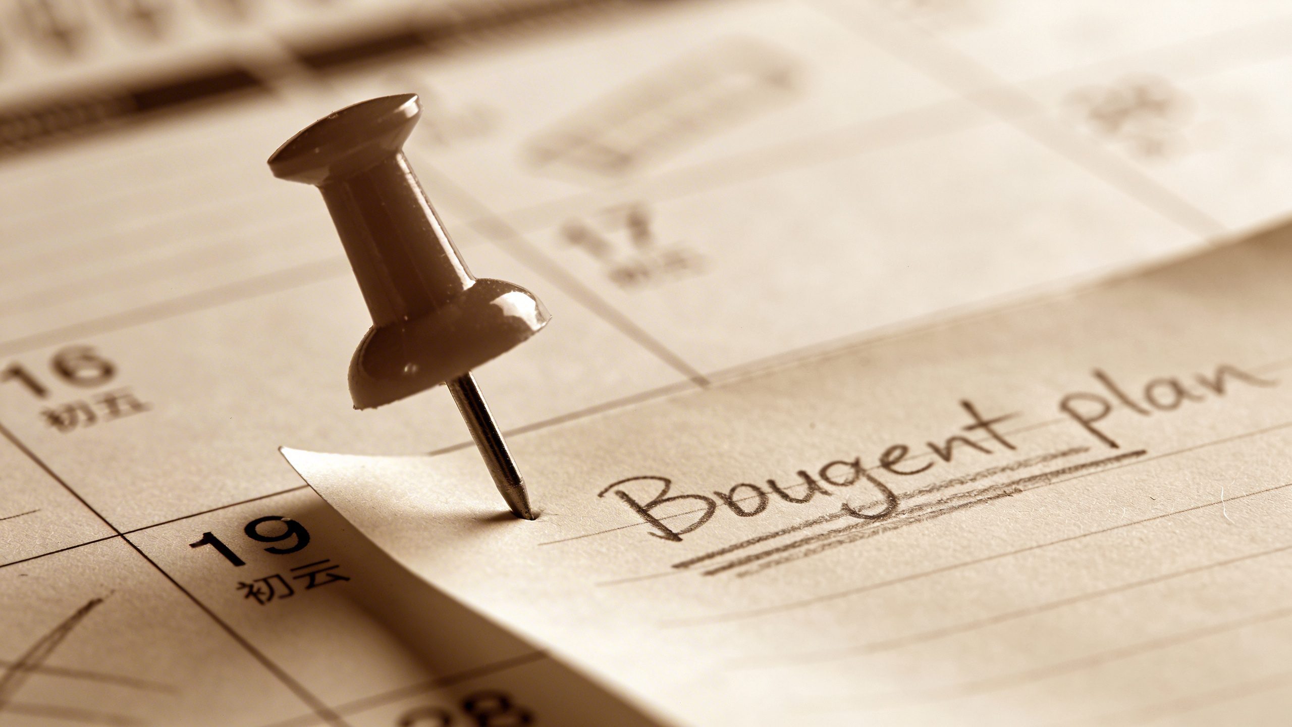 Closeup of a single calendar milestone with a budget plan note