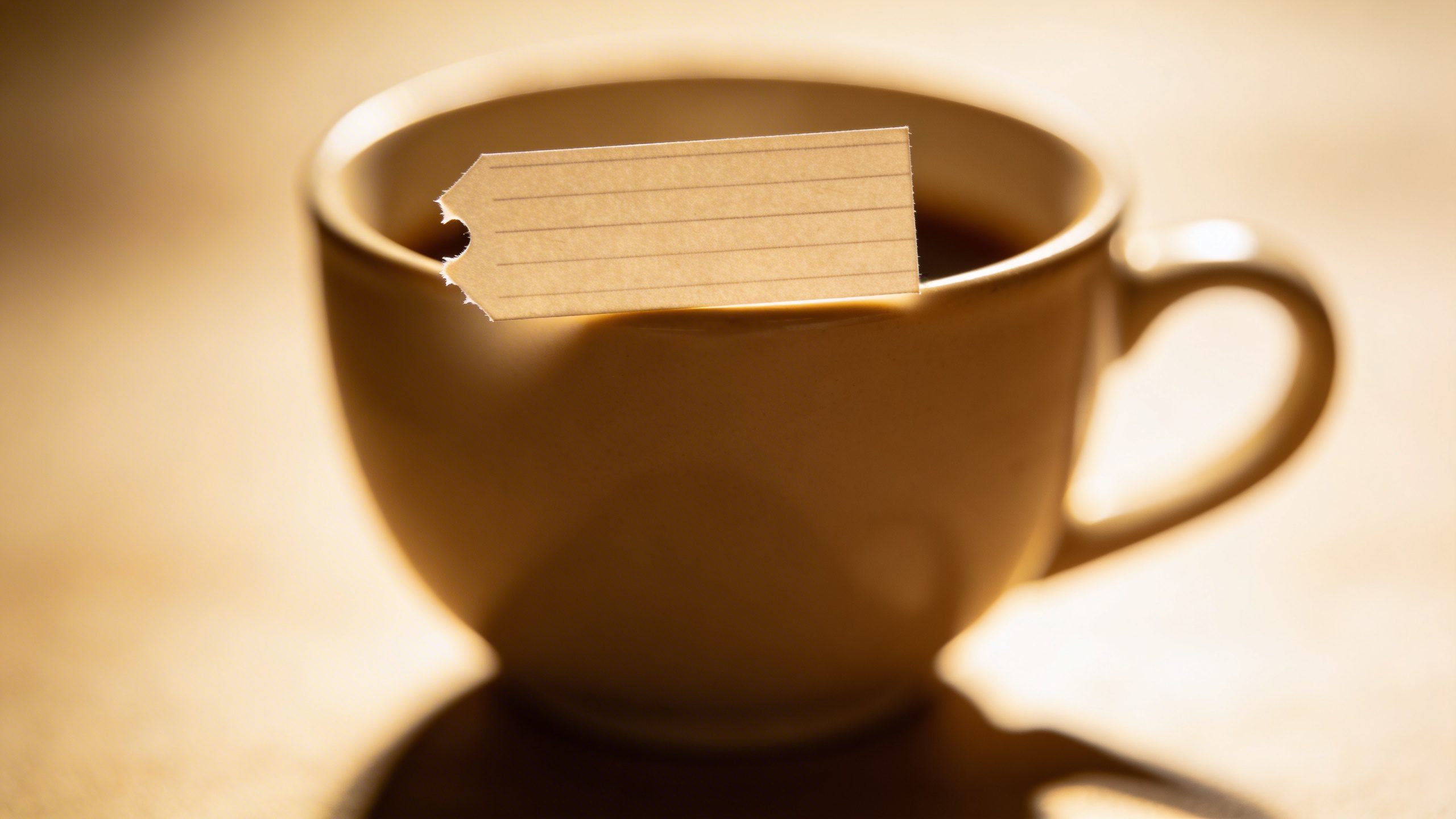 Closeup of a single coffee cup with a tiny price tag note