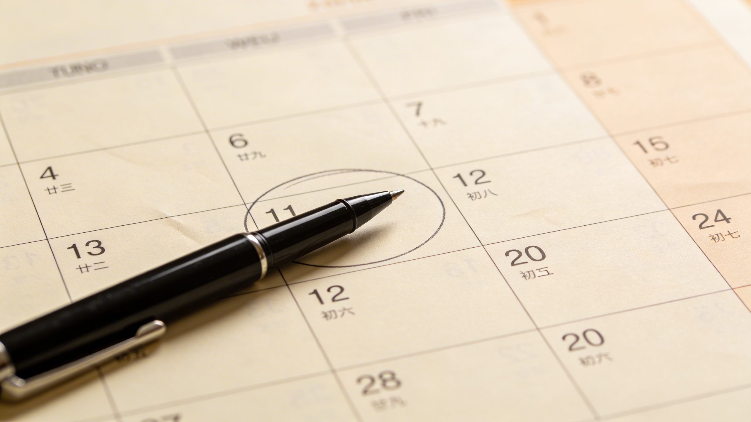 Closeup of a single calendar page marking a monthly budgeting date with pen