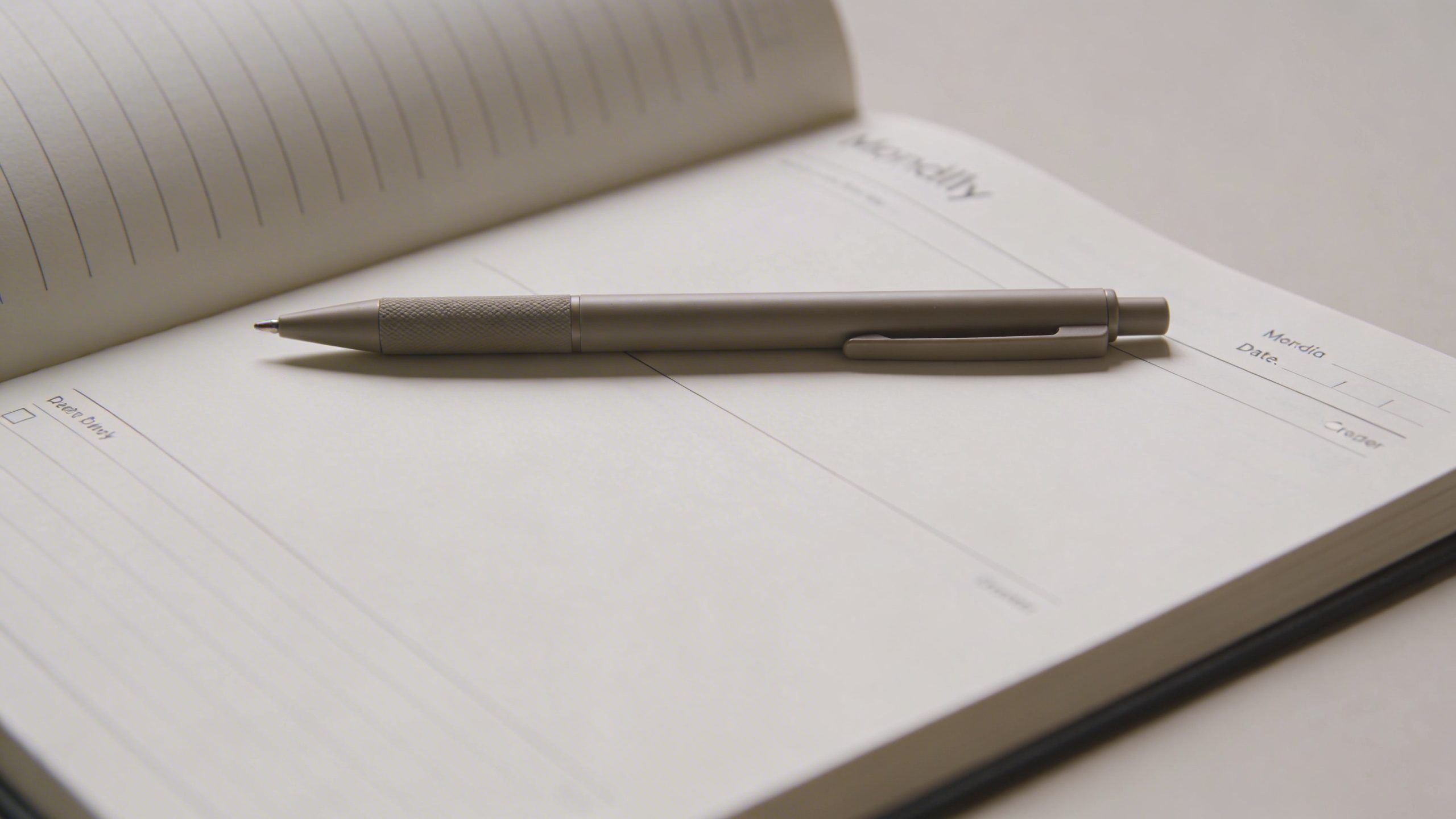 closeup of a minimalist monthly budget notebook відк with a single pen