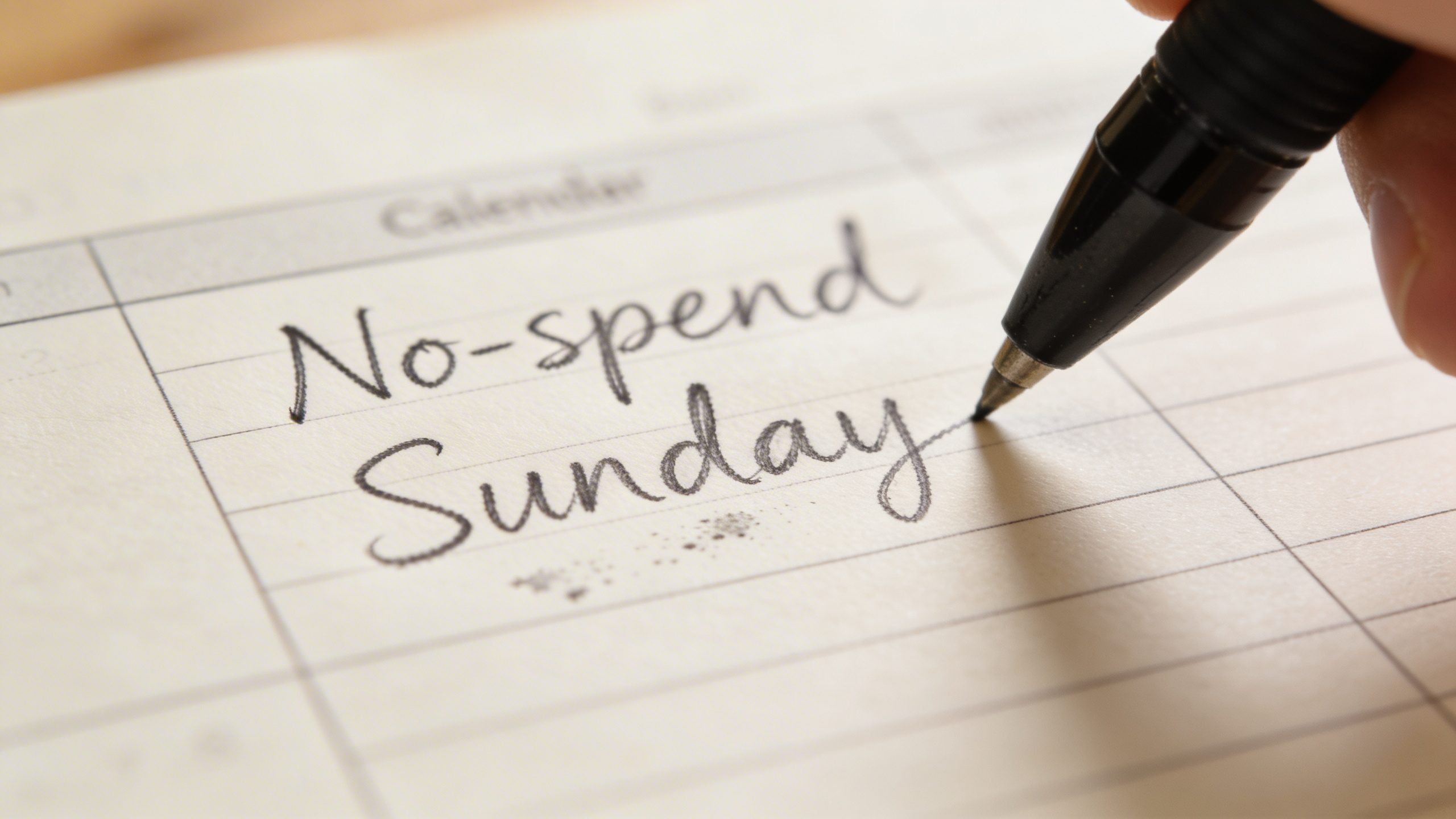 closeup of a single handwritten “No-spend Sunday” calendar note