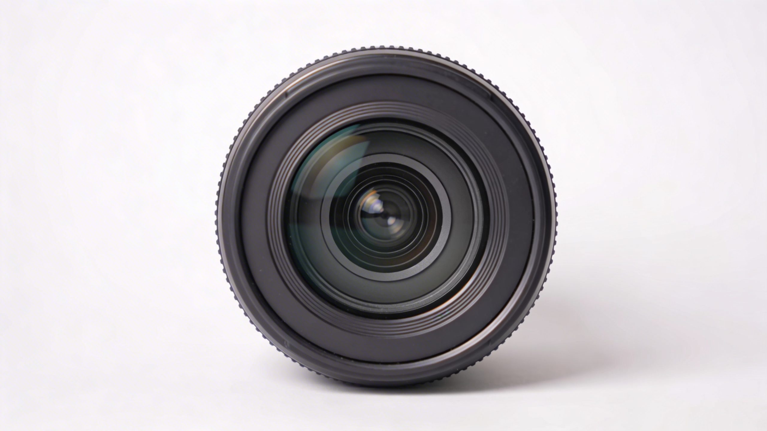 closeup of a single camera lens on a clean white backdrop