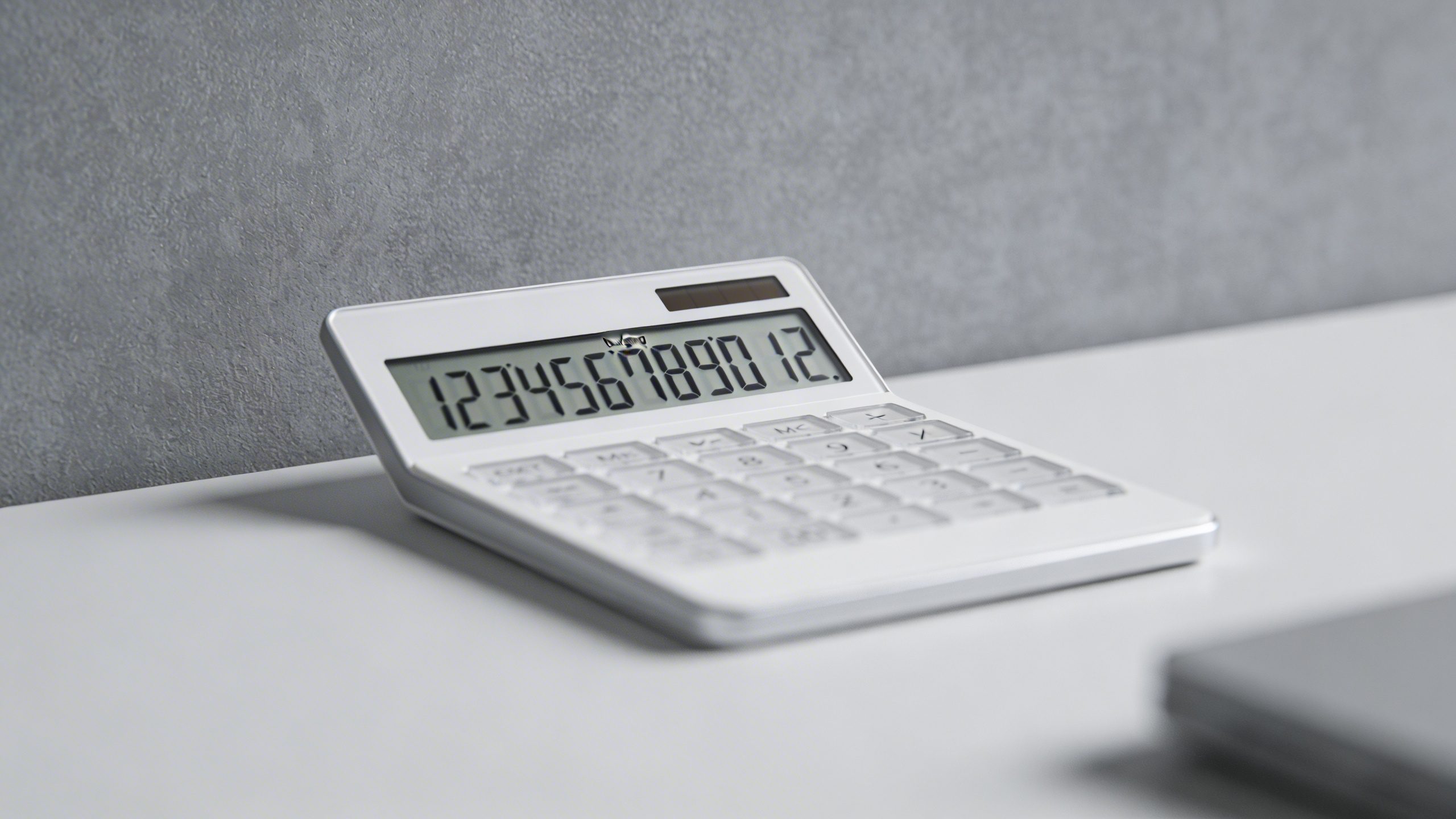 Closeup of a single calculator screen showing budgeting numbers, on a clean desk matte backdrop