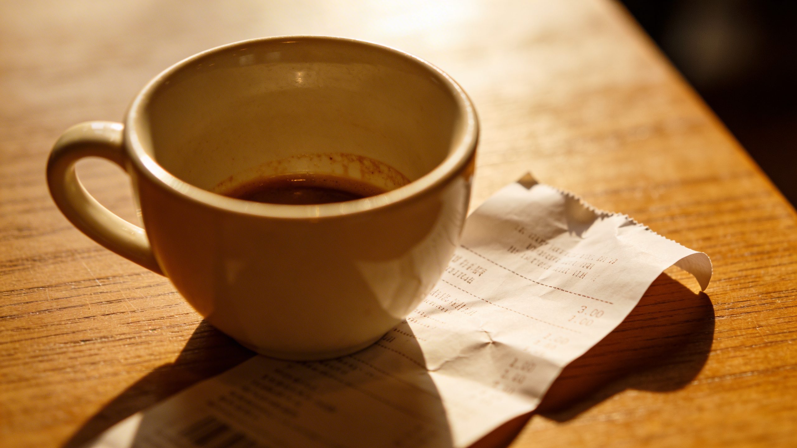 closeup of a single coffee cup with a visible receipt beside it