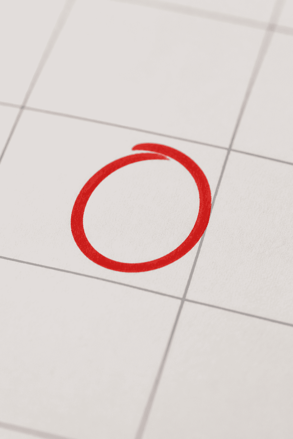 Closeup of a single bright red goal marker on a calendar page